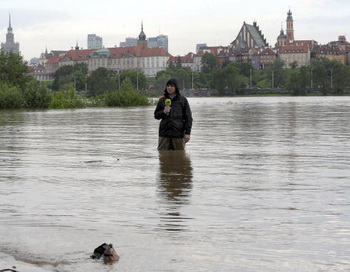 Телерепортер в Варшаве освещает ситуацию с наводнением на реке Висла. Фото: JANEK SKARZYNSKI/AFP/Getty Images