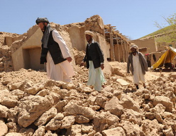 Афганские мужчины проходят мимо развалин домов после землетрясения. Фото: MASSOUD HOSSAINI/AFP/Getty Images