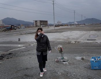 11 марта 2012 года г-жа Коматсу возлогает цветы на месте гибели её друзей в городке Рикузентаката в Японии во время цунами 9 марта 2011 года. Г-жа Kоматсу живет с мужем и двумя детьми во временном жилье, после того как они потеряли свои дом в результате цунами. Фото: Chris McGrath / Getty Images