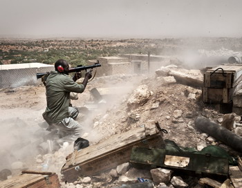 Ливийские повстанцы занимают позиции во время боя с войсками ливийского лидера Муамара Каддафи в регионе Западных Гор в июле 2011 года. Фото: COLIN SUMMERS/AFP/Getty Images