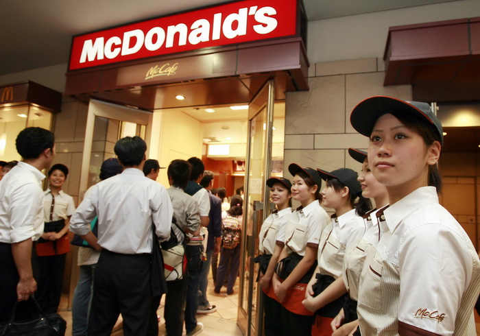 Официанты «Макдоналдса» встречают клиентов у входа в кафе. Япония. Фото: YOSHIKAZU TSUNO/AFP/Getty Images 