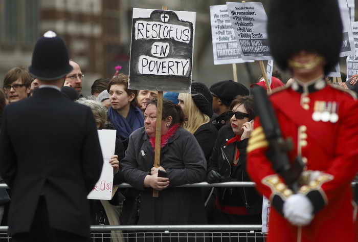  Протестующие держали плакаты на улицах во время торжественных похорон британского экс-премьера Маргарет Тэтчер. Фото: JUSTIN TALLIS/AFP/Getty Images