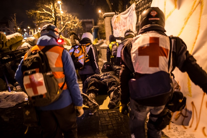 Медработники Майдана эвакуируют раненых демонстрантов в ходе столкновения с милицией на улице Грушевского, возле стадиона 