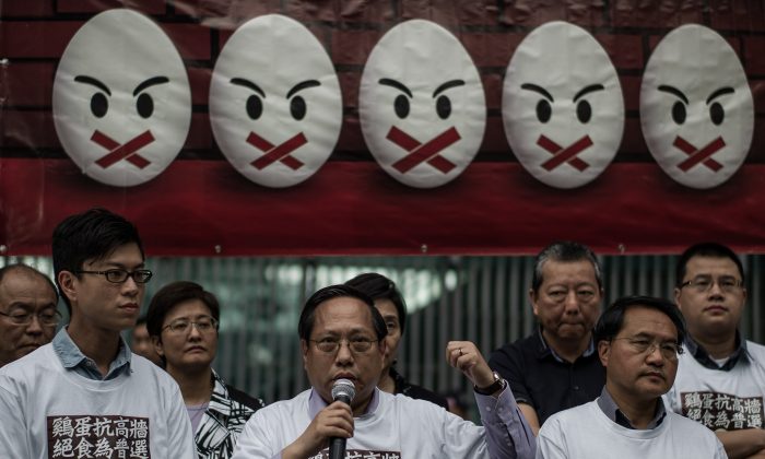 Протестующие встают под знаменем, готовясь к голодовке, призывая к «истинному» - всеобщему избирательному праву в Гонконге 28 марта 2014 года. В акции приняли участие около 15 пан-демократов, в том числе пятеро городских законодателей. голодовка, усиленная акция, поскольку опасения, что вмешательство Китая может помешать подлинной политической реформе, усилились. (Филипп Лопес / AFP / Getty Images) | Epoch Times Россия