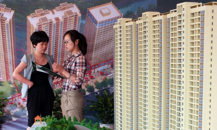 Китайский покупатель жилья спрашивает о новом проекте квартиры, выставленном на ярмарке недвижимости в Ичане, в провинции Хубэй в центральном Китае, 18 мая 2012 г. (AFP / AFP / Getty Images) | Epoch Times Россия