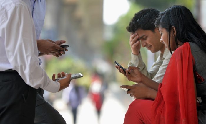 Согласно исследованию почти 3000 городских жителей Бангалора, около четырех процентов употребляют свои мобильные телефоны. В апреле Индия открыла в Бангалоре первый в стране центр лечения технологической зависимости, чтобы помочь первому поколению технологических наркоманов. Фотография сделана 30 января (Manjunath Kiran / AFP / Getty Images) | Epoch Times Россия