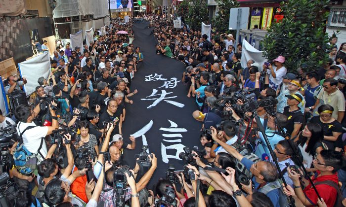 4000 сторонников гонконгского движения Occupy Central участвовали в марше Black Cloth March в черных рубашках и желтых ленточках и с 450-метровыми черными транспарантами в центре Гонконга 14 сентября 2014 г. (Pan Zaishu / Epoch Times) | Epoch Times Россия