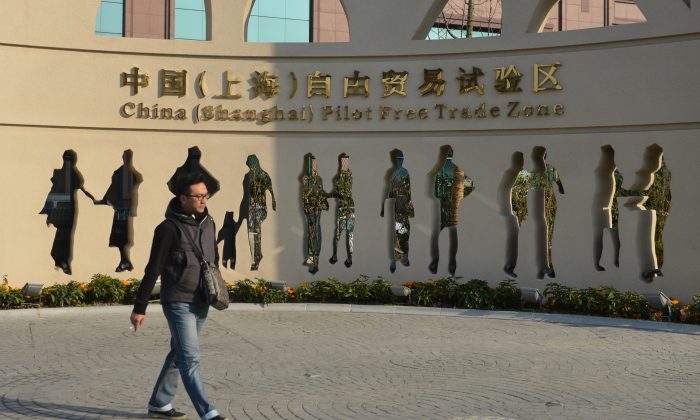 Посетитель проходит мимо дизайна, рекламирующего недавно открытую Шанхайскую экспериментальную зону свободной торговли 28 ноября 2013 года. Китайские власти заявили, что разрешат иностранным больницам работать в семи городах и провинциях. (Питер Паркс / AFP / Getty Images) | Epoch Times Россия