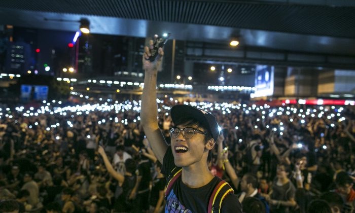 Протестующие светят светом из своих мобильных телефонов, скандируя продемократические лозунги на улицах Гонконга 30 сентября 2014 года. США и Канада выступили с заявлениями в поддержку продемократического движения Гонконга. (Паула Бронштейн / Getty Images) | Epoch Times Россия