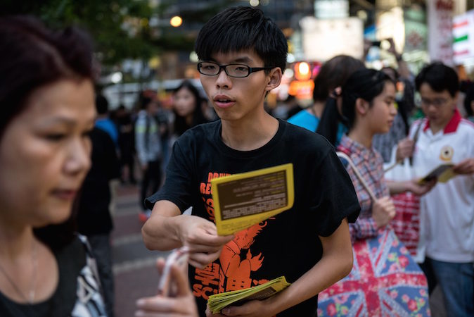 Студенческий лидер Джошуа Вон раздаёт листовки в поддержку демократических протестов в районе Causeway Bay, Гонконг, 16 ноября 2014 года. Фото: Alex Ogle/AFP/Getty Images | Epoch Times Россия