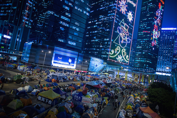 Протестующие проходят мимо палаток их главного лагеря в Адмиралтейском районе Гонконга 3 декабря 2014 года. Фото: Lam Yik Fei/Getty Images | Epoch Times Россия