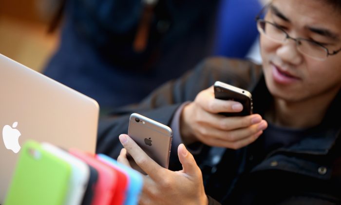 Мужчина устанавливает свой новый iPhone 6 в магазине Apple Store 17 октября 2014 года в Пекине, Китай. Китайская фирма утверждает, что Apple нарушила патент на дизайн iPhone 6. (Feng Li / Getty Images) | Epoch Times Россия