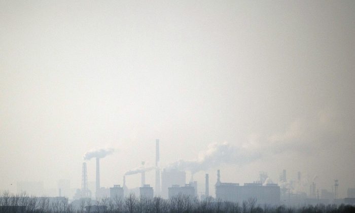 В воздухе поднимается дым от химического завода недалеко от Хэншуй в провинции Хэбэй на севере Китая, 22 декабря 2014 года. Многие мужчины умерли от рака в деревне на юге Китая, окруженной десятками фабрик, выбрасывающих высокие уровни загрязняющих веществ. (Фред Дюфур / AFP / Getty Images) | Epoch Times Россия