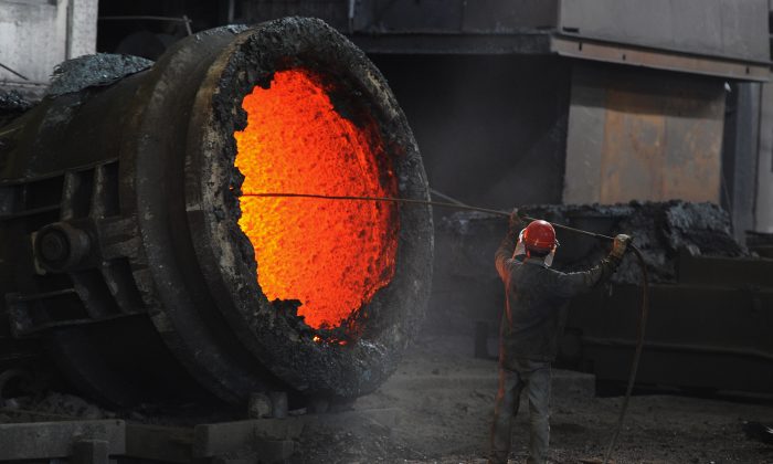 Китайский рабочий топит горящий котел на сталелитейном заводе в Хэфэй, Аньхой, Китай, 25 июня 2011 г. (STR / AFP / Getty Images) | Epoch Times Россия