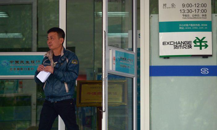 На этой файловой фотографии мужчина выходит из банка в Пекине 31 октября 2013 года. Новые правила потребуют от иностранных технологических компаний, обслуживающих банки в Пекине, предоставить свой исходный код и установить бэкдоры в свое программное обеспечение. (Ван Чжао / AFP / Getty Images) | Epoch Times Россия
