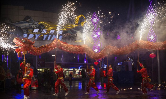 Китайские артисты исполняют танец дракона в местном парке развлечений во время празднования Лунного Нового года 19 февраля 2015 года в Пекине. Десятки китайских пользователей сети подняли петицию, призывающую к отмене гала-концерта CCTV в честь китайского Нового года, осуждая дискриминационное и сексистское содержание выступлений. (Кевин Фрайер / Getty Images) | Epoch Times Россия