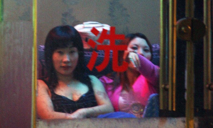 Китайские проститутки ждут клиентов в борделе Шанхая, 29 ноября 2006 года. По данным гонконгского журнала Chengming, в 2014 году должностные лица Коммунистической партии Китая и правительства были вовлечены в более 700 000 внебрачных связей. (Марк Ральстон / AFP / Getty Images) | Epoch Times Россия
