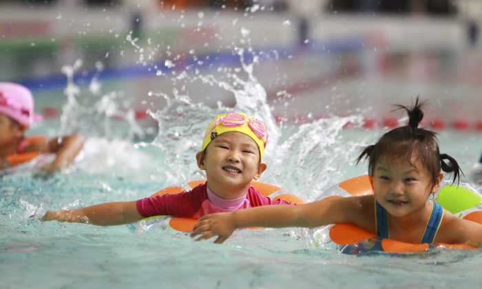 Группа маленьких китайских детей плавает в Пекине 22 сентября 2012 года. Премьер-министр Китая Ли Кэцян заявил 5 марта, что Китай может реформировать свою противоречивую политику одного ребенка. (STR / AFP / Getty Images) | Epoch Times Россия