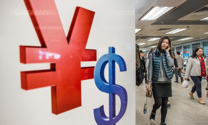 Символы китайского юаня (L) и доллара США в магазине в Гонконге. (Филипп Лопес / AFP / Getty Images) | Epoch Times Россия
