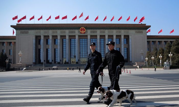 Два полицейских с собаками охраняют фасад Большого зала народных собраний в Пекине 13 марта 2015 г. (Lintao Zhang / Getty Images) | Epoch Times Россия