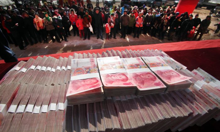 Тайник юаней в Цзинане, Китай, 20 января 2014 года. Центральный режим хочет использовать деньги для контроля над местными органами власти. (STR / AFP / Getty Images) | Epoch Times Россия