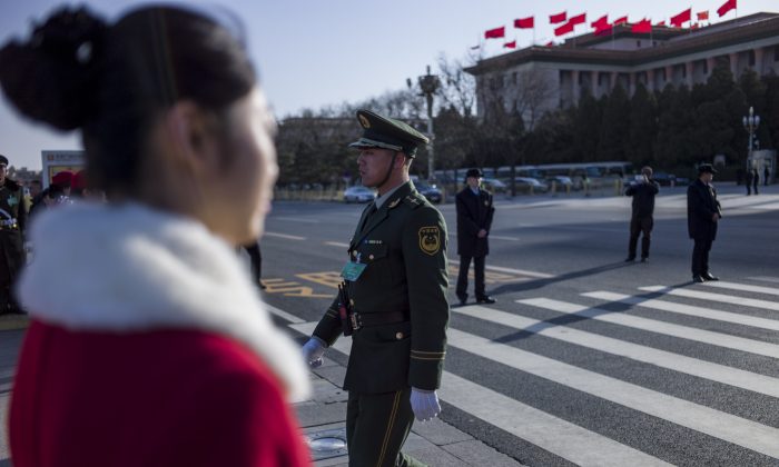 Офицер полиции переходит дорогу во время открытия Китайской народной политической консультативной конференции (НПКСК) в Большом зале народных собраний в Пекине 3 марта 2015 г. (Fred Dufour / AFP / Getty Images) | Epoch Times Россия