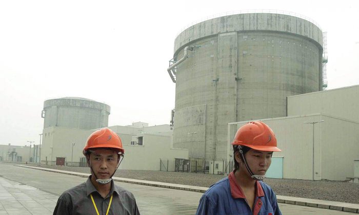 Рабочие проходят мимо атомной электростанции в Циньшане, в 90 милях к юго-западу от Шанхая, Китай, 10 июня 2005 г. (AP Photo / Eugene Hoshiko) | Epoch Times Россия