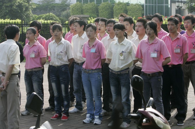 Китайские рабочие собираются на утреннюю «летучку» на заводе в городе Фошань провинции Гуандун 18 июня 2010 года. Рабочие в провинции Гуандун в последнее время стали требовать соблюдения трудового законодательства. Фото: STR/AFP/Getty Images | Epoch Times Россия