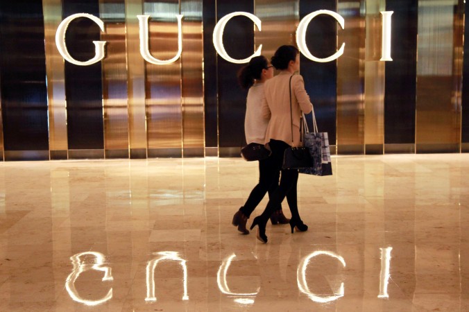 Китайские покупатели проходят мимо магазина Gucci в Нанкине, 9 ноября 2013 года. Фото: STR/AFP/Getty Images | Epoch Times Россия