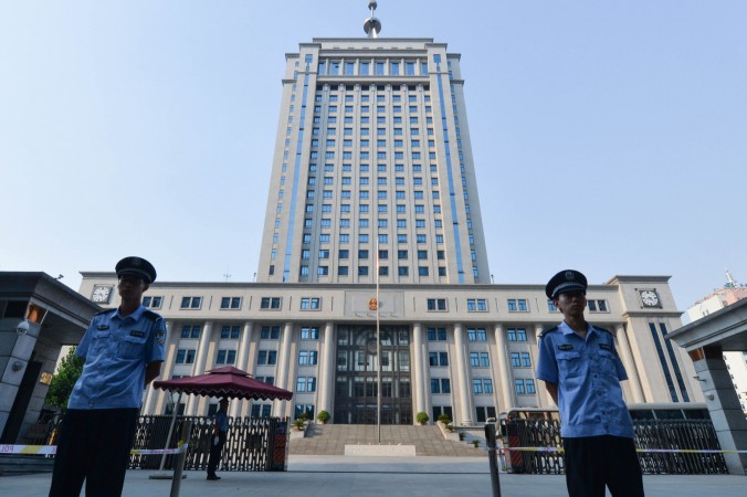 Полицейские дежурят у входа в здание суда города Цзинань провинции Шаньдун 21 августа 2013 года. Фото: Mark Ralston/AFP/Getty Images | Epoch Times Россия