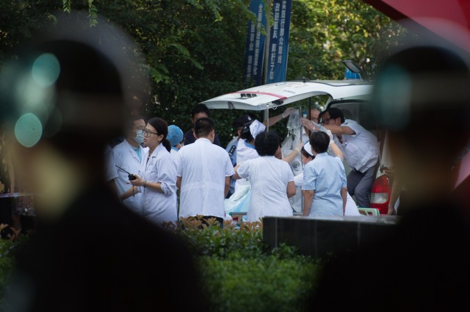 Врачи и медсёстры оказывают первую помощь жертве взрыва на заводе в Китае 2 августа 2014 года. Фото: Johannes EiseleE/AFP/Getty Images | Epoch Times Россия