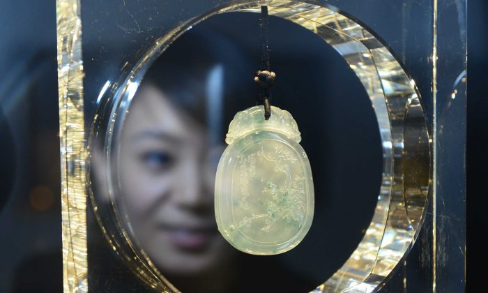 Женщина смотрит на украшение на Китайской международной ювелирной выставке в Пекине, 16 декабря 2012 г. (STR / AFP / Getty Images) | Epoch Times Россия
