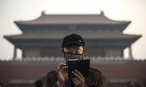 Китаец использует свой смартфон за пределами Запретного города в Пекине 20 ноября 2014 г. (Кевин Фрайер / Getty Images) | Epoch Times Россия