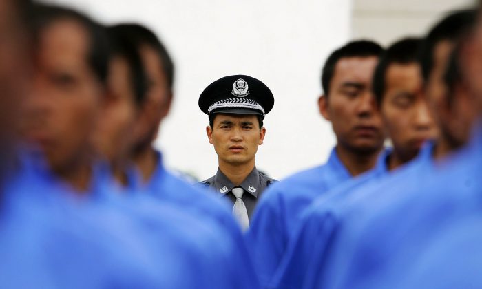 Китайский полицейский (C) инструктирует пациентов реабилитации от наркозависимости попрактиковаться в марше на территории муниципального центра принудительной реабилитации Куньмин 8 июля 2005 года в Куньмин, провинция Юньнань, Китай. (Гуан Ню / Getty Images) | Epoch Times Россия