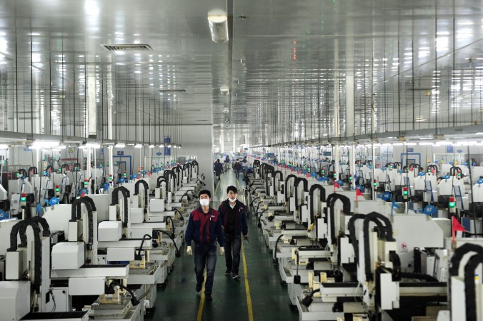 Рабочие на оптической фабрике в Люян провинции Хунань, 12 марта 2015 года. Фото: STR/AFP/Getty Images | Epoch Times Россия