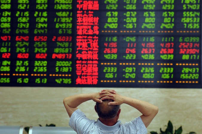 Работник биржи смотрит на курс акций, г. Фуян, провинция Аньхуэй, Китай, 19 июня 2015 г. Фото: STR/AFP/Getty Images | Epoch Times Россия