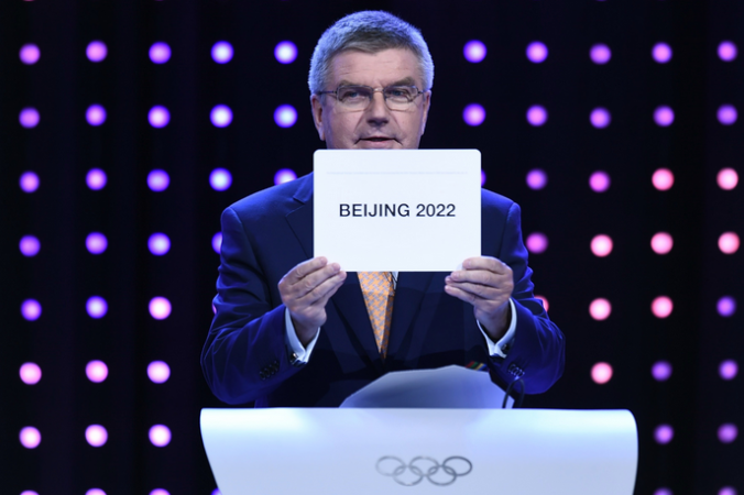 Президент Международного Олимпийского комитета Томас Бах показывает табличку с названием города (Пекин), получившего право на проведение Олимпиады -2022. Малайзия, Куала-Лумпур. Фото:  MANAN VATSYAYANA/Getty Images | Epoch Times Россия
