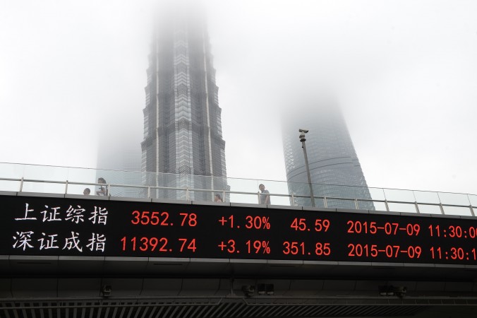 Индекс Шанхайской (сверху) и Шэньчжэньской бирж у Всемирного финансового центра в Шанхае, 9 июля 2015 года. Фото: STR/AFP/Getty Images | Epoch Times Россия