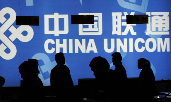 Покупатели рассматривают товары в магазине China Unicom в Пекине 9 ноября 2004 года. Следователи Коммунистической партии недавно обнаружили широко распространенный кумовство в этой компании. (Питер Паркс / AFP / Getty Images). | Epoch Times Россия