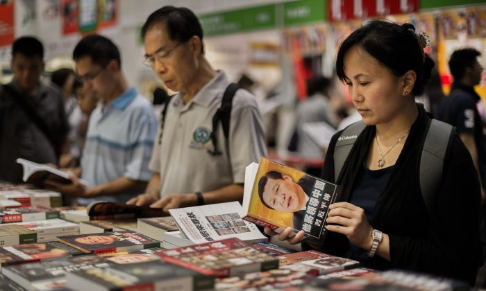 Посетители просматривают китайские политические книги на Гонконгской книжной ярмарке в Гонконге 18 июля 2012 г. (Philippe Lopez / AFP / GettyImages) | Epoch Times Россия