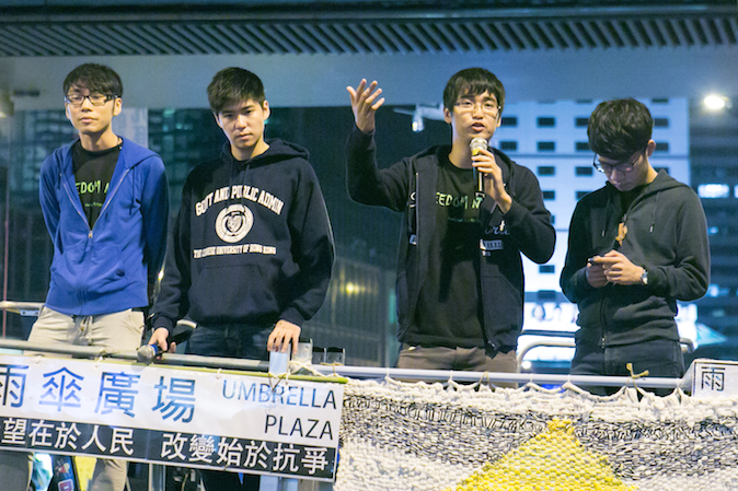 Алекс Чоу, генеральный секретарь Федерации студентов Гонконга, вместе с другими лидерами выступает перед демонстрантами после того, как ему отказали во въезде в Пекин, 15 ноября 2014 года. Фото: Benjamin Chasteen/Epoch Times | Epoch Times Россия