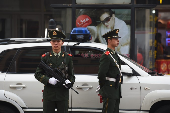 Офицеры китайской военизированной полиции наблюдают за пешеходами в районе Ванфуцзин в Пекине 24 октября 2014 года. Фото: Greg Baker/AFP/Getty Images | Epoch Times Россия