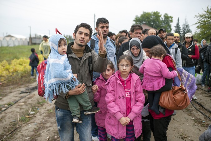 Мигранты и беженцы стоят в очереди, чтобы войти после пересечения границы с Грецией в лагерь в Македонии, около Гевгелии, 8 октября 2015 года. Фото: Robert Atanasovski/AFP/Getty Images | Epoch Times Россия
