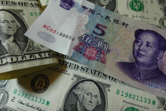 Юани и доллары на столе, Ичан, провинция Хубэй, Китай, 14 августа 2014 года. Фото: STR/AFP/Getty Images | Epoch Times Россия