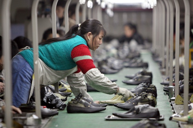Работница раскладывает обувь по конвейеру на фабрике в городе Чэнду. Фото: China Photos/Getty Images | Epoch Times Россия