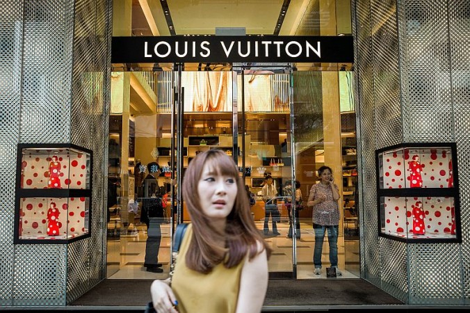 Девушка проходит мимо магазина Louis Vuitton в Гонконге, сентябрь 2012 г. Фото: PHILIPPE LOPEZ/AFP/Getty Images | Epoch Times Россия