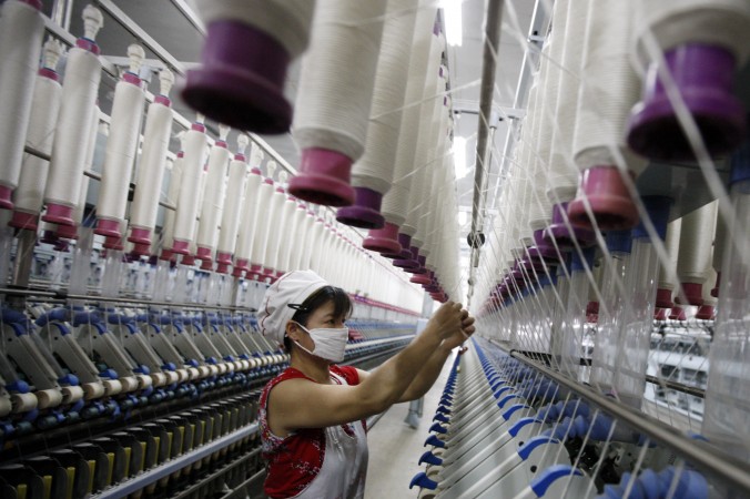 Рабочая на текстильной фабрике в Хуайбэй, Китай, 24 июля 2013 г. Фото: STR/AFP/Getty Images | Epoch Times Россия
