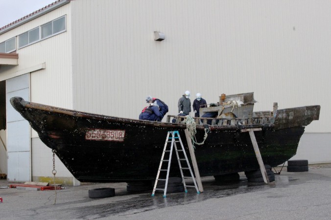 На этом фото, снятом 24 ноября 2015 г. японская береговая охрана изучает деревянную лодку в порту Фукуи в городе Сакаи, западная Япония. За последние два месяца к побережью Японии прибило дюжину странных судов с разложившимися телами моряков. Некоторые СМИ сообщили о северокорейском происхождении лодок. Фото: JIJI PRESS/AFP/Getty Images | Epoch Times Россия