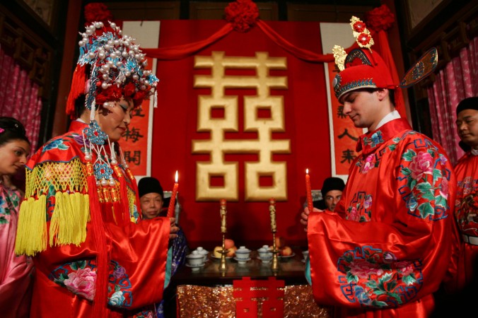 Жених ― из Франции, а невеста ― из Китая празднуют свадьбу в китайском стиле, 5 мая 2007 г., Пекин, Китай. Фото: China Photos/Getty Images | Epoch Times Россия