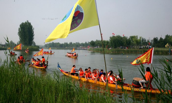 Лодки-драконы, отправляющиеся в ежегодную гонку вдоль реки в Биньчжоу, провинция Шаньдун на северо-востоке Китая. Гонки на лодках-драконах насчитывают более 2000 лет и теперь превратились в серьезный вид спорта в календаре многих стран по всему миру. (STR / AFP / Getty Images) | Epoch Times Россия